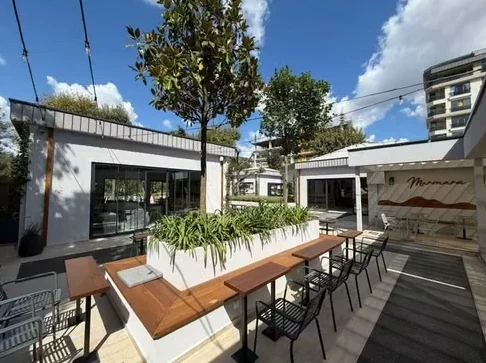 Saksı bölücülü uzun masalar ve kafe binası